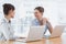 Businesswoman laughing together at desk