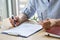 Businesswoman lawyer read partnership contract at table holding glasses. Closeup