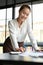 Businesswoman leaning on the table, reading and reviewing financial report