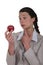 Businesswoman looking at an apple.