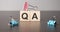 Businesswoman made word qa with wood building blocks