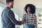 businesswoman making handshake with a businessman in office