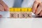 Businesswoman Measuring Risk Blocks With Measuring Tape