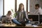 Businesswoman meditating at workplace, avoiding problem at work