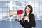 Businesswoman with megaphone and thumbs up