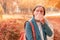 Businesswoman nose-blowing paper tissue in autumnal park