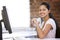 Businesswoman in office drinking coffee