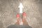 Businesswoman with orange shoes standing on asphalt street with white arrow