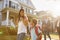 Businesswoman Parents Walking Children To School On Way To Work