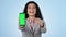 Businesswoman, phone and pointing at you with green screen in studio for opportunity on blue background. Entrepreneur