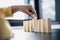 Businesswoman picking up a block of wood from a row, solving problems that arise during planned business operations.