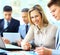 Businesswoman posing while colleagues talking together in bright office