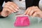 Businesswoman Putting Coin Into Pink Purse