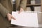 Businesswoman putting document into punched pocket in office, closeup