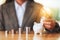 A businesswoman putting a light bulb over a piggy bank with coins stack on the table for financial concept