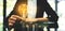 Businesswoman putting lightbulb over coins stack on table