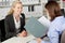 Businesswoman Reading Female Candidate\'s CV At Desk