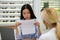 Businesswoman reading text from paper while visiting ophthalmologist