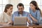 Businesswoman realtor consulting young couple at meeting, using laptop