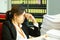 Businesswoman resting hands on head with eyes close at work desk in office.