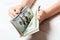 Businesswoman`s hands counting one hundred and other dollar bills on wooden background. Salary and wage concept. Perspective view