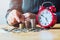 businesswoman saving money with hand putting coins stack and red