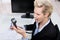 Businesswoman Shouting On Telephone Receiver At Desk