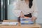 A businesswoman is sifting through stacks of paper files and folders that contain both incomplete and completed