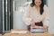 A businesswoman is sifting through stacks of paper files and folders that contain both incomplete and completed