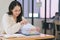 A businesswoman is sifting through stacks of paper files and folders that contain both incomplete and completed