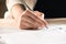 Businesswoman signing contract documents sitting at table