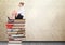 Businesswoman sitting Books stacked by decorative wallpaper antique