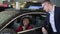 Businesswoman sitting into car and talking to male salesperson in dealership office spbd.