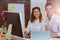 Businesswoman sitting with coworker while working on computer