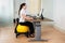 Businesswoman Sitting On Fitness Ball With Computer At Desk