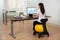 Businesswoman Sitting On Fitness Ball In Office