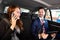 Businesswoman sitting inside car beside her male colleague