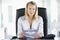 Businesswoman sitting in office with personal