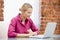 Businesswoman sitting in office using laptop