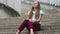 Businesswoman sitting on stairs with papers. Professional meditating on street