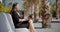 Businesswoman sitting working in an urban park