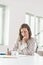 Businesswoman sitting writing notes at her desk