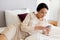 Businesswoman with smartphone at hotel room