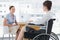 Businesswoman speaking with disabled colleague