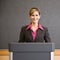 Businesswoman standing behind podium