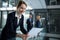 Businesswoman standing in corridor reading document in office