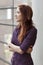 Businesswoman standing at window gazing upward