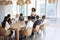 Businesswoman Stands To Address Meeting Around Board Table