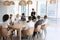 Businesswoman Stands To Address Meeting Around Board Table