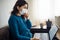 Businesswoman stays home and works during coronavirus epidemia quarantine. Female worker wearing a medical mask, coughs and typing